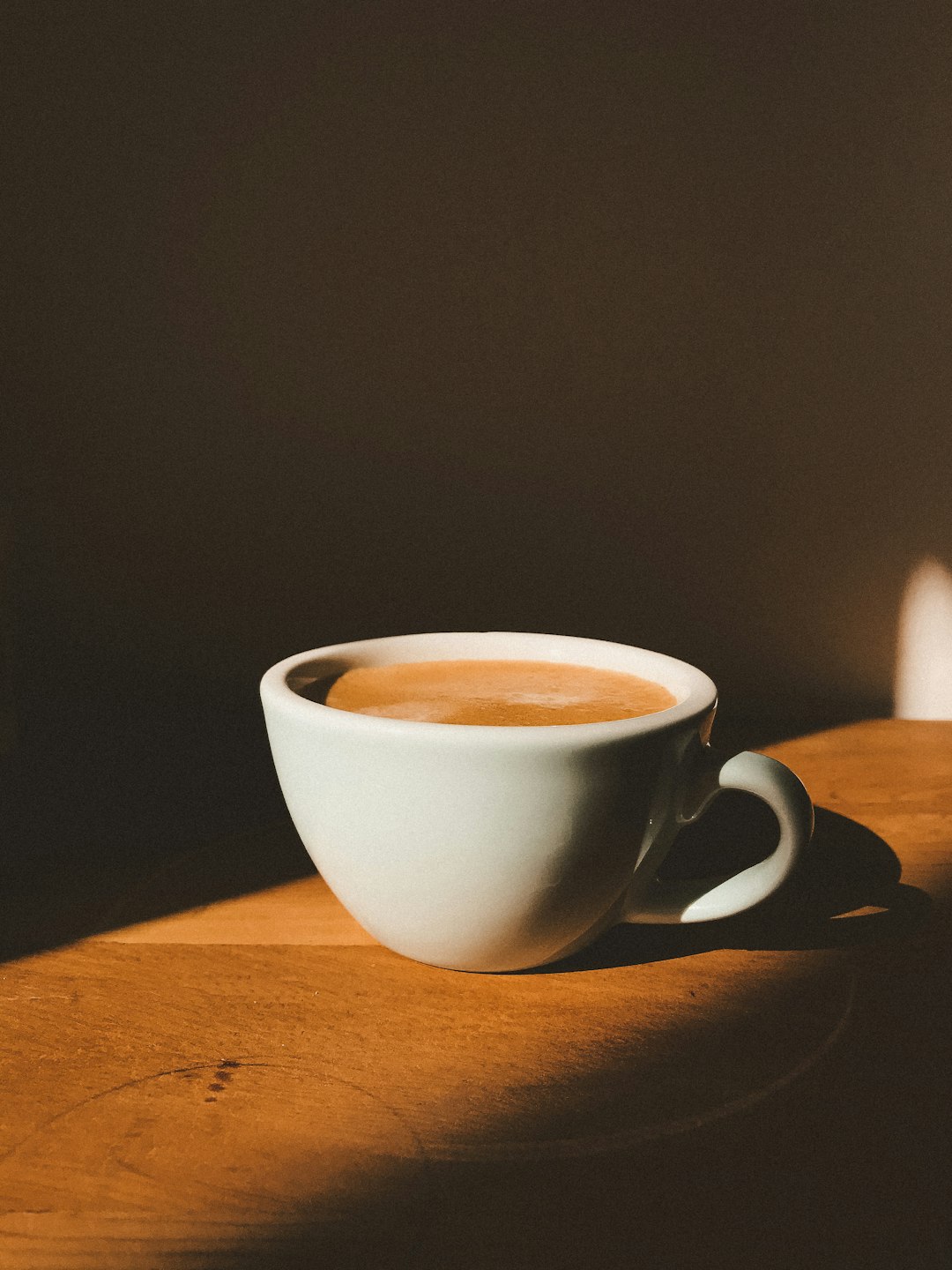 white-ceramic-cup-on-brown-wooden-table-dqdyo9jsixa